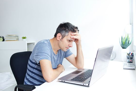 Foto | mand ser opgivende på sin PC